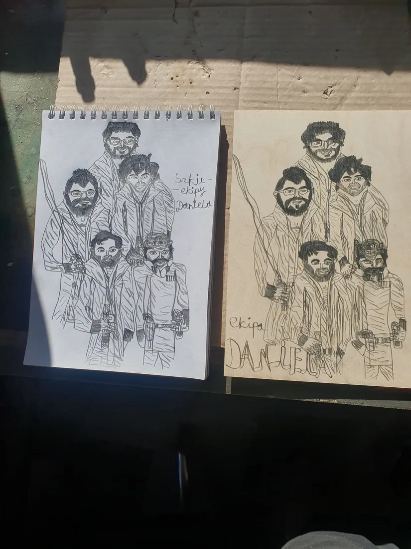 A notebook sketch of five figures lies next to a board with the same drawing