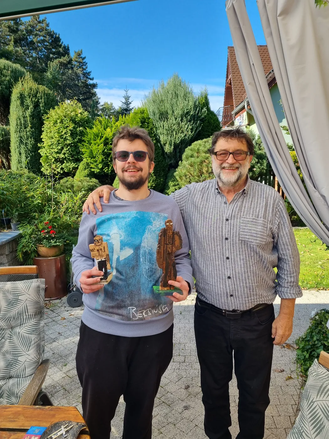 Michał Walczyk z obrazem w rękach i Pavel Konečný stoją w ogrodzie