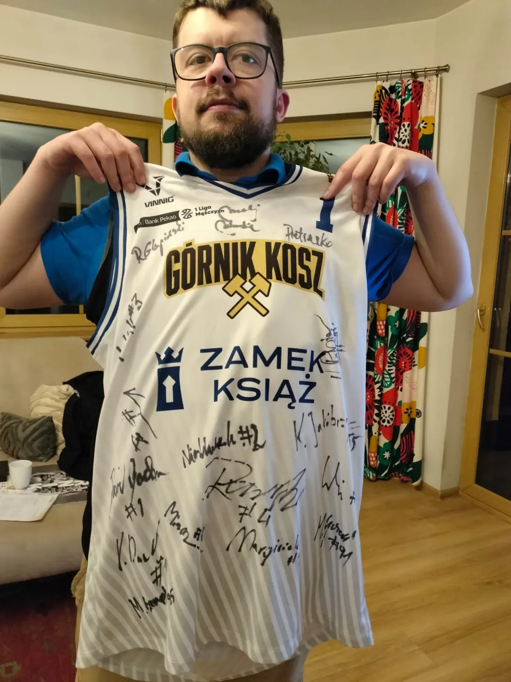 Michał Walczyk trzyma białą koszulkę Górnika Wałbrzych z podpisami