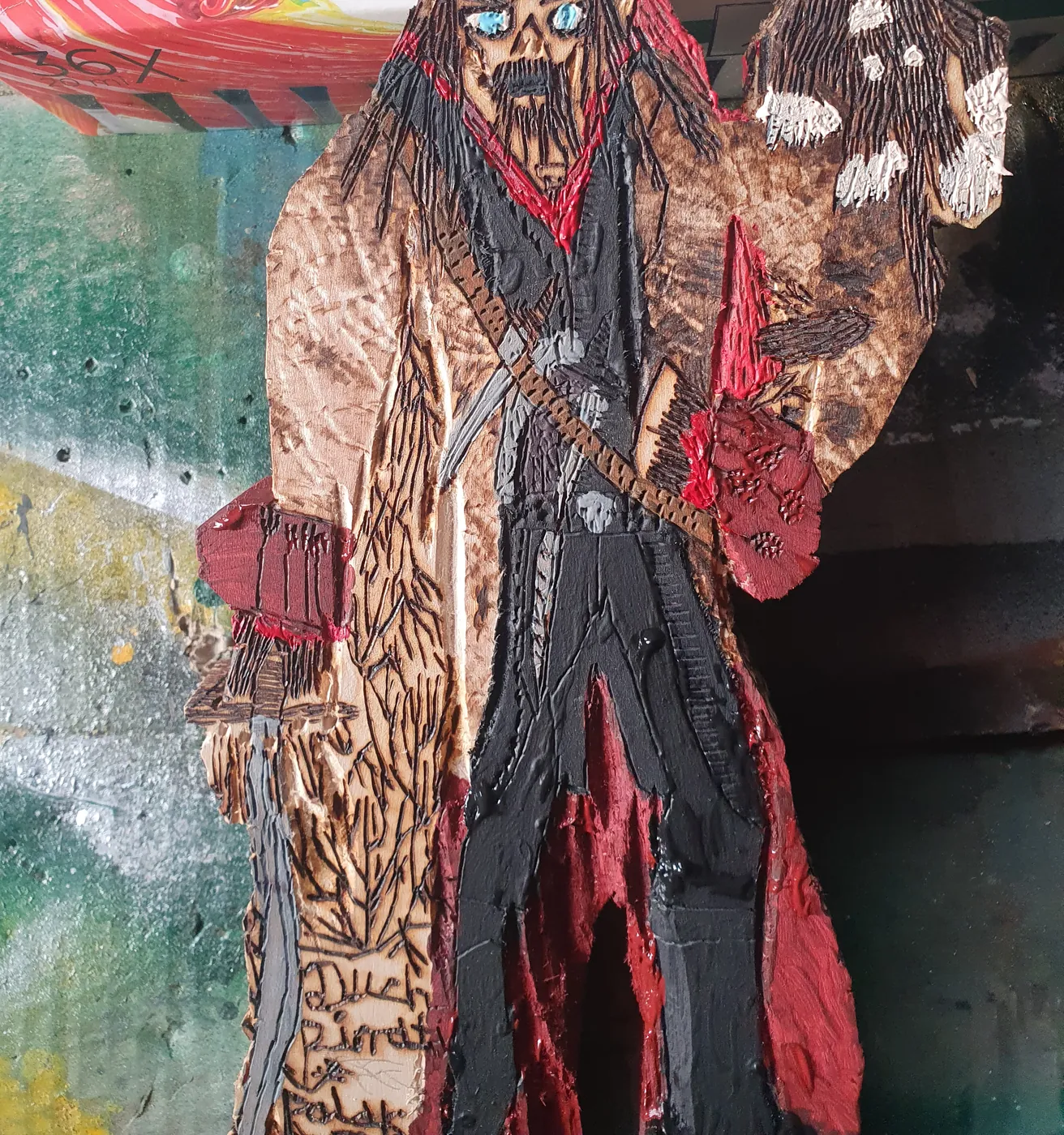 Pomalowana figurka pirata: czerwona chusta, czarne spodnie, na ramieniu małpka